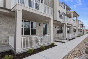 Property entrance featuring a porch and stone siding