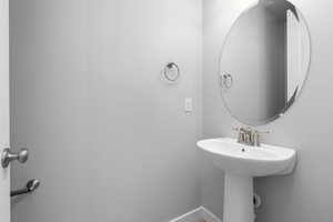 Bathroom featuring baseboards and a sink