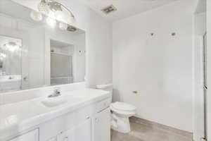 Full bath featuring toilet, vanity, and a shower stall