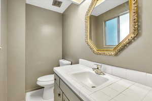Half bathroom featuring toilet and vanity