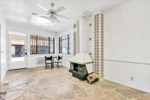 Sunroom featuring a wood stove and a wall mounted AC
