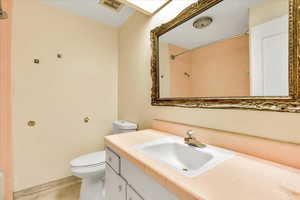 Full bath with toilet, vanity, and a shower