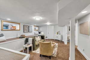 Carpeted living area with baseboards and recessed lighting