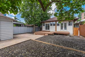 Back of property with french doors, a fenced backyard, a deck, and a gazebo