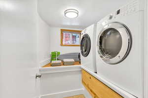 Laundry room featuring washing machine and clothes dryer and baseboards