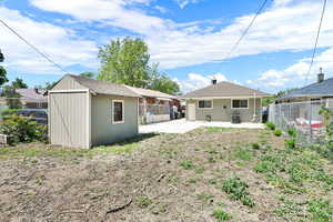Back of house with a patio, a fenced backyard, and central AC