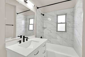 Full bathroom with vanity, tub / shower combination, plenty of natural light, and toilet