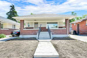 Bungalow-style house with brick siding and a porch