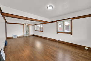 Unfurnished room with dark wood-style floors and baseboards
