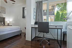 Bedroom with dark wood-type flooring, a desk, and ceiling fan