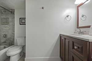 Bathroom featuring vanity, shower / bathtub combination, and a textured ceiling