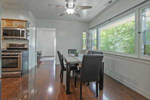 Dining area featuring dark wood-style flooring and ceiling fan