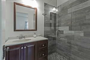 Full bath with a shower stall and vanity