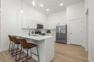 Kitchen with stainless steel appliances, quartz counters, tile backsplash