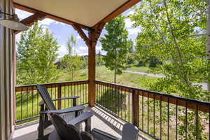 Balcony featuring view of wooded area