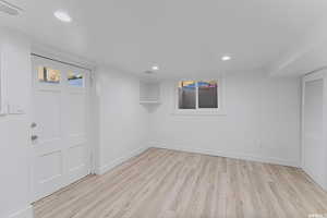 Below grade area featuring light wood-style floors, recessed lighting, and baseboards