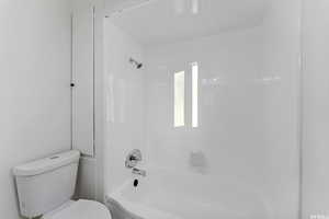 Full bath featuring toilet and shower / bath combination