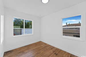 Spare room with baseboards and wood finished floors