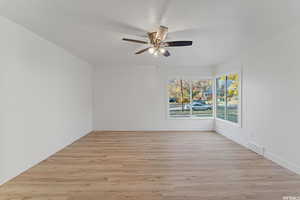 Unfurnished room featuring ceiling fan, light wood-style flooring, and baseboards