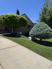 View of side of home featuring a yard and brick siding