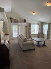 Living area featuring vaulted ceiling, carpet, and baseboards