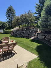 View of grassy yard featuring a patio area