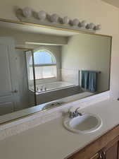 Full bath featuring a bath, vanity, and a shower stall