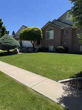 View of front facade featuring brick siding and a front lawn