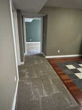 Hallway featuring carpet flooring and baseboards