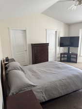 Carpeted bedroom featuring lofted ceiling and ceiling fan
