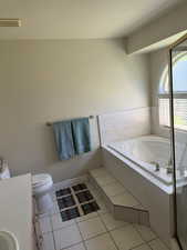 Bathroom with vanity, a bath, toilet, tile patterned flooring, and a shower with shower door