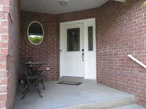 Doorway to property featuring brick siding