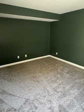 Unfurnished room featuring carpet and baseboards