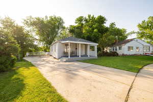 View of front of home featuring covered porch, concrete driveway, and a front lawn