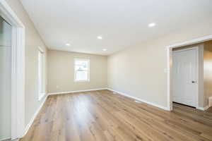 Unfurnished room featuring light wood-style floors, baseboards, and recessed lighting