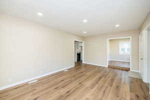 Spare room with light wood-style flooring, baseboards, and recessed lighting