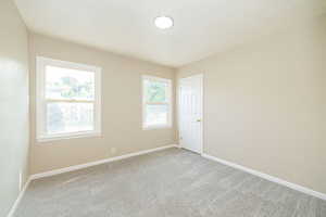 Spare room with light carpet and baseboards