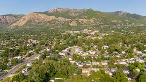 Aerial view of property and surrounding area with a mountain backdrop