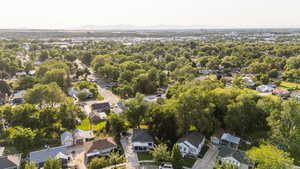 Aerial view of property and surrounding area featuring a mountain backdrop and nearby suburban area