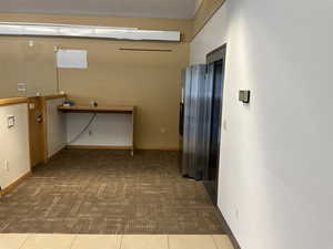 Corridor with carpet flooring and baseboards