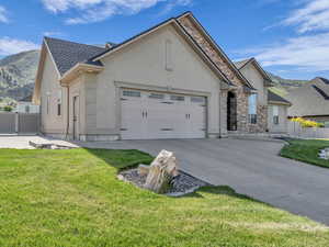 View of front of home featuring stucco siding, concrete driveway, a garage, and stone siding