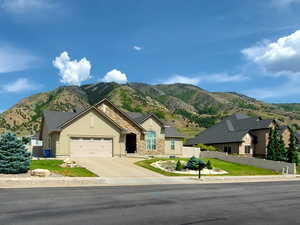 View of asphalt road featuring a mountain view and sidewalks