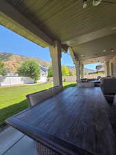 Back patio with a mountain view, a fenced backyard, and an outdoor hangout area. Taken at 2 pm.