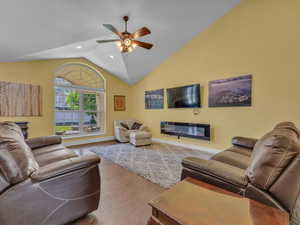 Living area with wood finished floors, a ceiling fan, vaulted ceiling, recessed lighting, and baseboards