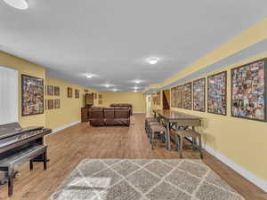 Dining area featuring a textured ceiling, wood finished porcelain tile floors, and baseboards.
