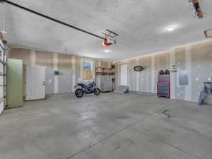 Garage with electric panel and a garage door opener