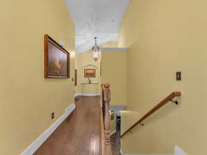 Stairs with a chandelier, baseboards, and wood finished floors