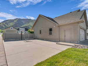 View of property exterior with a mountain view, roof with shingles, and stucco siding