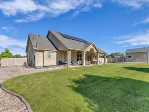 Back of house featuring an outdoor living space, roof mounted solar panels, a patio area, central AC, and roof with shingles