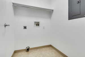 Laundry area with electric panel, baseboards, washer hookup, and electric dryer hookup